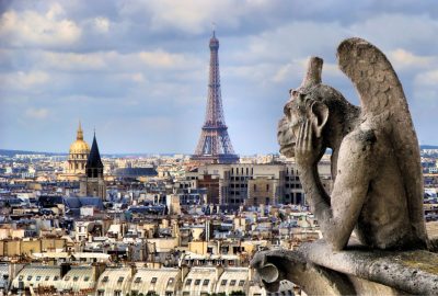 Gargoyle at the top of Notre Dame and Paris cityscape