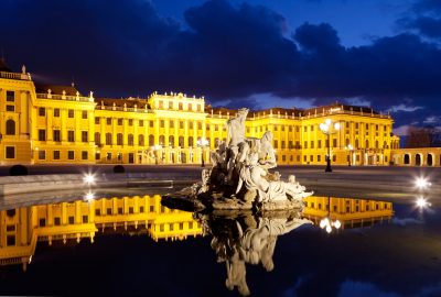 Schonbrunn palace in Vienna by night with fountain in the foreground 
