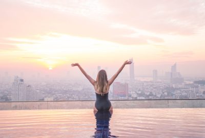 Escort at rooftop swimming pool to backdrop of Bangkok's skyline