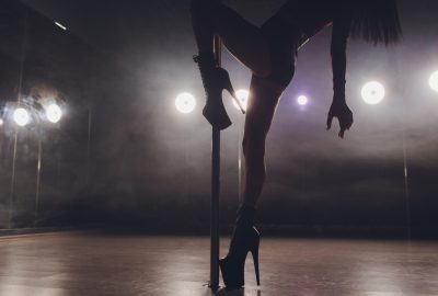 Pole dance on stage in dimmed lights at Lisbon striptease club