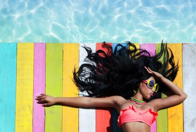 Escort in Santo Domingo sunbathing at swimming pool in resort during adult vacation