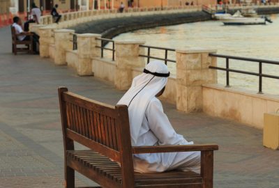 Local inhabitant of Dubai sitting on bench at Dubai Creek