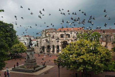 Parque Colon in Santo Domingo with Cathedral and Columbus statue visited by flock of pingeons