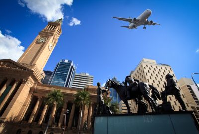 View of City Hall and King George Square in Brisbane with a plane flying over them