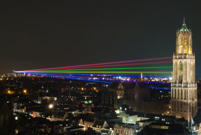 Utrecht Dom Tower illuminated by coloured laser light beams